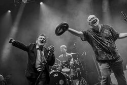 Das schwarz-weiß Foto zeigt die Bandmitglieder im vollen Einsatz.