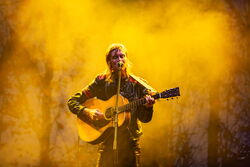 Anna Ternheim, steht in dichtem Nebel vor einem Mikrofon und spielt Gitarre. Sie wird mit warmen, gelben Licht angestrahlt.